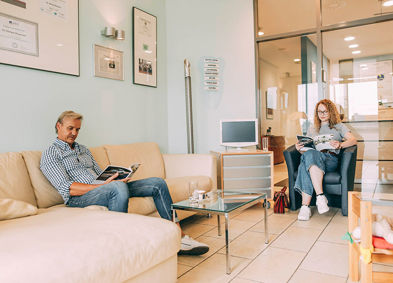 Patienten warten im gemütlichen Wartezimmer in der Zahnarztpraxis Plugmann